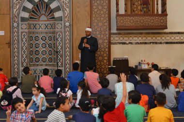 Kahire, Mısır, 31 Mayıs 2022: Cami vaizi İmam, camideki çocuklara yönelik yaz İslami eğitim programı sırasında camide genç Müslüman çocuklara vaaz veriyor.