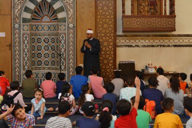 Kahire, Mısır, 31 Mayıs 2022: Cami vaizi İmam, camideki çocuklara yönelik yaz İslami eğitim programı sırasında camide genç Müslüman çocuklara vaaz veriyor.