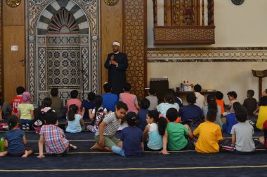 Kahire, Mısır, 31 Mayıs 2022: Cami vaizi İmam, camideki çocuklara yönelik yaz İslami eğitim programı sırasında camide genç Müslüman çocuklara vaaz veriyor.