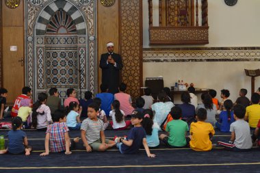 Kahire, Mısır, 31 Mayıs 2022: Cami vaizi İmam, camideki çocuklara yönelik yaz İslami eğitim programı sırasında camide genç Müslüman çocuklara vaaz veriyor.