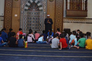 Kahire, Mısır, 31 Mayıs 2022: Cami vaizi İmam, camideki çocuklara yönelik yaz İslami eğitim programı sırasında camide genç Müslüman çocuklara vaaz veriyor.