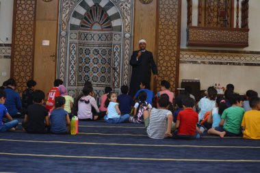 Kahire, Mısır, 31 Mayıs 2022: Cami vaizi İmam, camideki çocuklara yönelik yaz İslami eğitim programı sırasında camide genç Müslüman çocuklara vaaz veriyor.