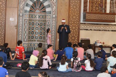 Kahire, Mısır, 31 Mayıs 2022: Cami vaizi İmam, camideki çocuklara yönelik yaz İslami eğitim programı sırasında camide genç Müslüman çocuklara vaaz veriyor.