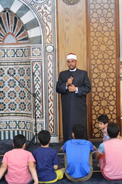 Kahire, Mısır, 31 Mayıs 2022: Cami vaizi İmam, camideki çocuklara yönelik yaz İslami eğitim programı sırasında camide genç Müslüman çocuklara vaaz veriyor.