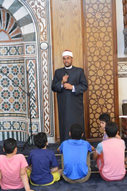 Kahire, Mısır, 31 Mayıs 2022: Cami vaizi İmam, camideki çocuklara yönelik yaz İslami eğitim programı sırasında camide genç Müslüman çocuklara vaaz veriyor.