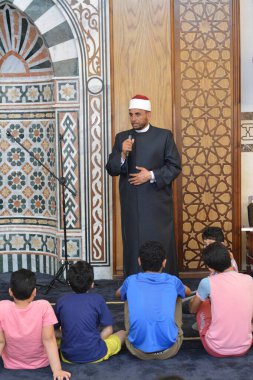 Kahire, Mısır, 31 Mayıs 2022: Cami vaizi İmam, camideki çocuklara yönelik yaz İslami eğitim programı sırasında camide genç Müslüman çocuklara vaaz veriyor.