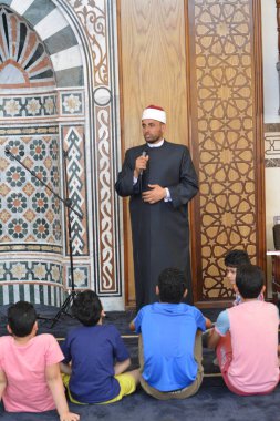 Kahire, Mısır, 31 Mayıs 2022: Cami vaizi İmam, camideki çocuklara yönelik yaz İslami eğitim programı sırasında camide genç Müslüman çocuklara vaaz veriyor.