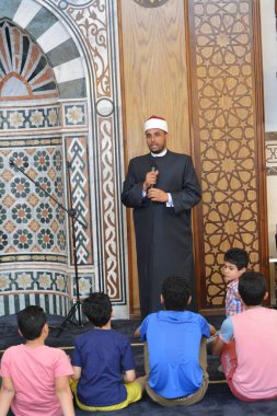 Kahire, Mısır, 31 Mayıs 2022: Cami vaizi İmam, camideki çocuklara yönelik yaz İslami eğitim programı sırasında camide genç Müslüman çocuklara vaaz veriyor.