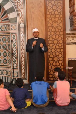 Kahire, Mısır, 31 Mayıs 2022: Cami vaizi İmam, camideki çocuklara yönelik yaz İslami eğitim programı sırasında camide genç Müslüman çocuklara vaaz veriyor.