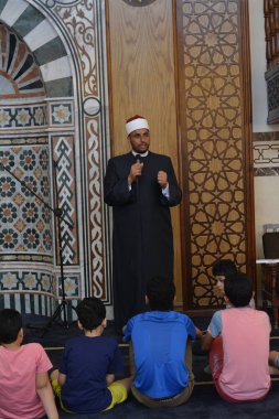 Kahire, Mısır, 31 Mayıs 2022: Cami vaizi İmam, camideki çocuklara yönelik yaz İslami eğitim programı sırasında camide genç Müslüman çocuklara vaaz veriyor.