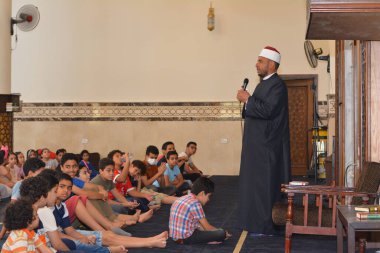 Kahire, Mısır, 31 Mayıs 2022: Cami vaizi İmam, camideki çocuklara yönelik yaz İslami eğitim programı sırasında camide genç Müslüman çocuklara vaaz veriyor.