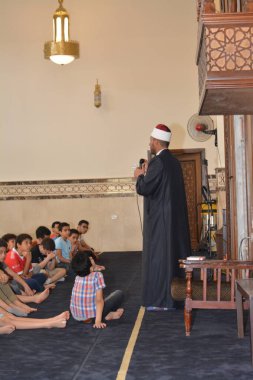 Kahire, Mısır, 31 Mayıs 2022: Cami vaizi İmam, camideki çocuklara yönelik yaz İslami eğitim programı sırasında camide genç Müslüman çocuklara vaaz veriyor.