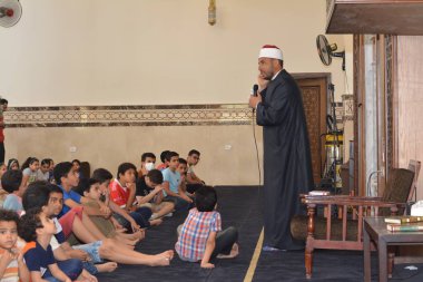 Kahire, Mısır, 31 Mayıs 2022: Cami vaizi İmam, camideki çocuklara yönelik yaz İslami eğitim programı sırasında camide genç Müslüman çocuklara vaaz veriyor.
