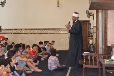 Kahire, Mısır, 31 Mayıs 2022: Cami vaizi İmam, camideki çocuklara yönelik yaz İslami eğitim programı sırasında camide genç Müslüman çocuklara vaaz veriyor.