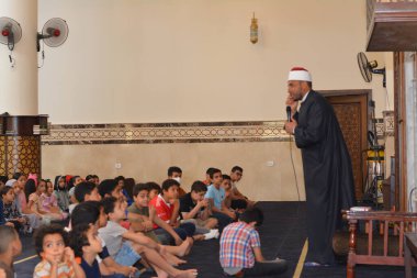 Kahire, Mısır, 31 Mayıs 2022: Cami vaizi İmam, camideki çocuklara yönelik yaz İslami eğitim programı sırasında camide genç Müslüman çocuklara vaaz veriyor.