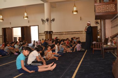 Kahire, Mısır, 31 Mayıs 2022: Cami vaizi İmam, camideki çocuklara yönelik yaz İslami eğitim programı sırasında camide genç Müslüman çocuklara vaaz veriyor.