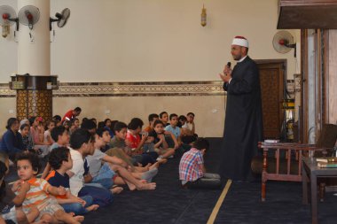 Kahire, Mısır, 31 Mayıs 2022: Cami vaizi İmam, camideki çocuklara yönelik yaz İslami eğitim programı sırasında camide genç Müslüman çocuklara vaaz veriyor.