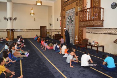 Kahire, Mısır, 31 Mayıs 2022: Cami vaizi İmam, camideki çocuklara yönelik yaz İslami eğitim programı sırasında camide genç Müslüman çocuklara vaaz veriyor.