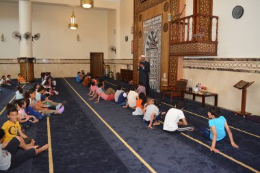 Kahire, Mısır, 31 Mayıs 2022: Cami vaizi İmam, camideki çocuklara yönelik yaz İslami eğitim programı sırasında camide genç Müslüman çocuklara vaaz veriyor.