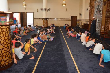 Kahire, Mısır, 31 Mayıs 2022: Cami vaizi İmam, camideki çocuklara yönelik yaz İslami eğitim programı sırasında camide genç Müslüman çocuklara vaaz veriyor.