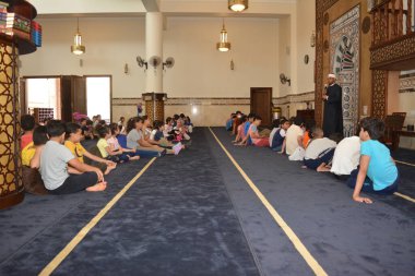 Kahire, Mısır, 31 Mayıs 2022: Cami vaizi İmam, camideki çocuklara yönelik yaz İslami eğitim programı sırasında camide genç Müslüman çocuklara vaaz veriyor.