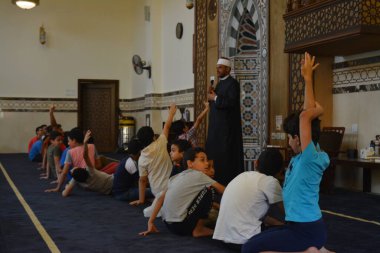 Kahire, Mısır, 31 Mayıs 2022: Cami vaizi İmam, camideki çocuklara yönelik yaz İslami eğitim programı sırasında camide genç Müslüman çocuklara vaaz veriyor.