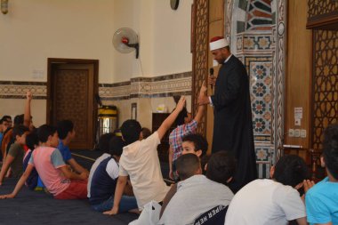 Kahire, Mısır, 31 Mayıs 2022: Cami vaizi İmam, camideki çocuklara yönelik yaz İslami eğitim programı sırasında camide genç Müslüman çocuklara vaaz veriyor.