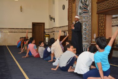 Kahire, Mısır, 31 Mayıs 2022: Cami vaizi İmam, camideki çocuklara yönelik yaz İslami eğitim programı sırasında camide genç Müslüman çocuklara vaaz veriyor.