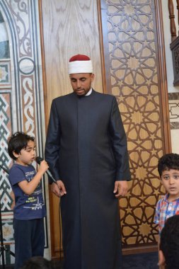Kahire, Mısır, 31 Mayıs 2022: Cami vaizi İmam, camideki çocuklara yönelik yaz İslami eğitim programı sırasında camide genç Müslüman çocuklara vaaz veriyor.
