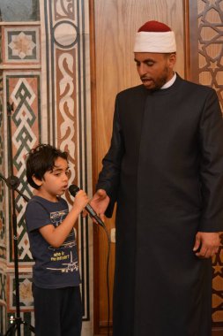 Kahire, Mısır, 31 Mayıs 2022: Cami vaizi İmam, camideki çocuklara yönelik yaz İslami eğitim programı sırasında camide genç Müslüman çocuklara vaaz veriyor.