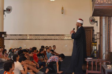 Kahire, Mısır, 31 Mayıs 2022: Cami vaizi İmam, camideki çocuklara yönelik yaz İslami eğitim programı sırasında camide genç Müslüman çocuklara vaaz veriyor.