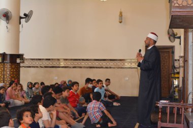 Kahire, Mısır, 31 Mayıs 2022: Cami vaizi İmam, camideki çocuklara yönelik yaz İslami eğitim programı sırasında camide genç Müslüman çocuklara vaaz veriyor.