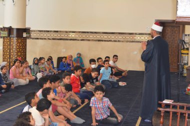 Kahire, Mısır, 31 Mayıs 2022: Cami vaizi İmam, camideki çocuklara yönelik yaz İslami eğitim programı sırasında camide genç Müslüman çocuklara vaaz veriyor.