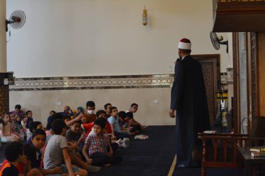 Kahire, Mısır, 31 Mayıs 2022: Cami vaizi İmam, camideki çocuklara yönelik yaz İslami eğitim programı sırasında camide genç Müslüman çocuklara vaaz veriyor.