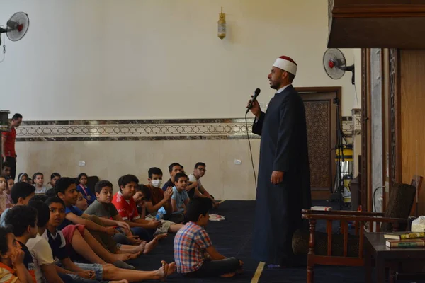 Kahire, Mısır, 31 Mayıs 2022: Cami vaizi İmam, camideki çocuklara yönelik yaz İslami eğitim programı sırasında camide genç Müslüman çocuklara vaaz veriyor.
