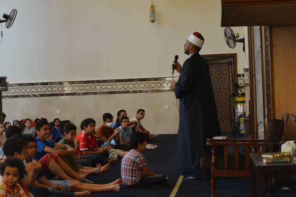 Kahire, Mısır, 31 Mayıs 2022: Cami vaizi İmam, camideki çocuklara yönelik yaz İslami eğitim programı sırasında camide genç Müslüman çocuklara vaaz veriyor.