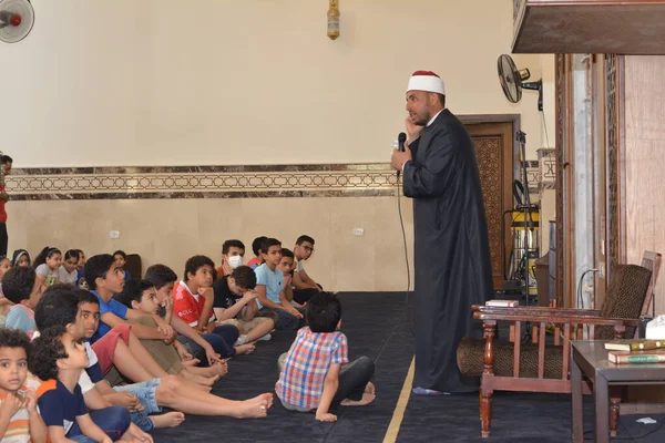 Kahire, Mısır, 31 Mayıs 2022: Cami vaizi İmam, camideki çocuklara yönelik yaz İslami eğitim programı sırasında camide genç Müslüman çocuklara vaaz veriyor.