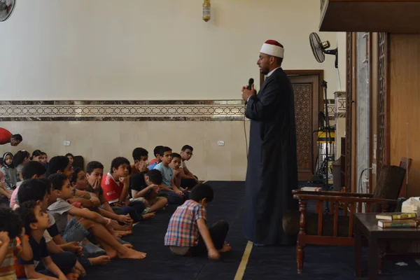 Kahire, Mısır, 31 Mayıs 2022: Cami vaizi İmam, camideki çocuklara yönelik yaz İslami eğitim programı sırasında camide genç Müslüman çocuklara vaaz veriyor.