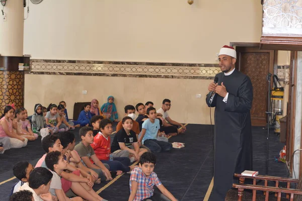Kahire, Mısır, 31 Mayıs 2022: Cami vaizi İmam, camideki çocuklara yönelik yaz İslami eğitim programı sırasında camide genç Müslüman çocuklara vaaz veriyor.