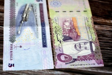 Suudi Arabistan 5 SAR Beş Suudi para banknotu Kral Salman bin AbdulAziz ve Ras Tanura tanker yükleme terminali, Jubayl Limanı, doğu bölgesi ahşap bir arka planda izole edilmiş