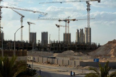 Giza, Mısır, 13 Haziran 2022: Plastik ve hasır ahşaptan yapılmış uçan bir uçurtma yeni binalar, vinçler ve dönümlerce lüks emlak konut binaları inşaatının arka planında
