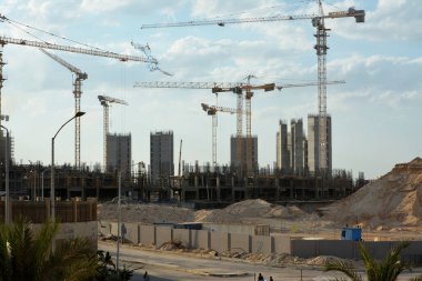 Giza, Mısır, 13 Haziran 2022: Plastik ve hasır ahşaptan yapılmış uçan bir uçurtma yeni binalar, vinçler ve dönümlerce lüks emlak konut binaları inşaatının arka planında