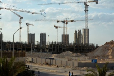 Giza, Mısır, 13 Haziran 2022: Plastik ve hasır ahşaptan yapılmış uçan bir uçurtma yeni binalar, vinçler ve dönümlerce lüks emlak konut binaları inşaatının arka planında