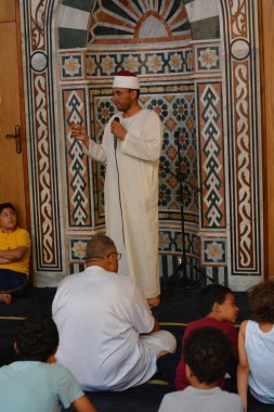 Kahire, Mısır, 30 Haziran 2022: Cami vaizi İmam camideki yaz İslam eğitim programı sırasında bir camide genç Müslüman çocuklara vaaz veriyor.