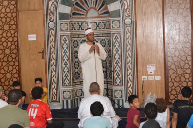 Kahire, Mısır, 30 Haziran 2022: Cami vaizi İmam camideki yaz İslam eğitim programı sırasında bir camide genç Müslüman çocuklara vaaz veriyor.