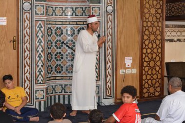 Kahire, Mısır, 30 Haziran 2022: Cami vaizi İmam camideki yaz İslam eğitim programı sırasında bir camide genç Müslüman çocuklara vaaz veriyor.
