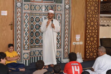 Kahire, Mısır, 30 Haziran 2022: Cami vaizi İmam camideki yaz İslam eğitim programı sırasında bir camide genç Müslüman çocuklara vaaz veriyor.
