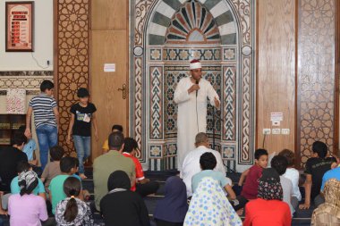 Kahire, Mısır, 30 Haziran 2022: Cami vaizi İmam camideki yaz İslam eğitim programı sırasında bir camide genç Müslüman çocuklara vaaz veriyor.