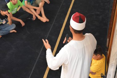 Kahire, Mısır, 30 Haziran 2022: Cami vaizi İmam camideki yaz İslam eğitim programı sırasında bir camide genç Müslüman çocuklara vaaz veriyor.
