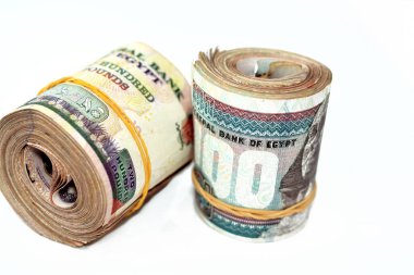 Egypt money roll pounds isolated on white background, 200 LE and 100 LE two hundred and one hundred Egyptian pounds cash money bills rolled up with rubber bands, selective focus
